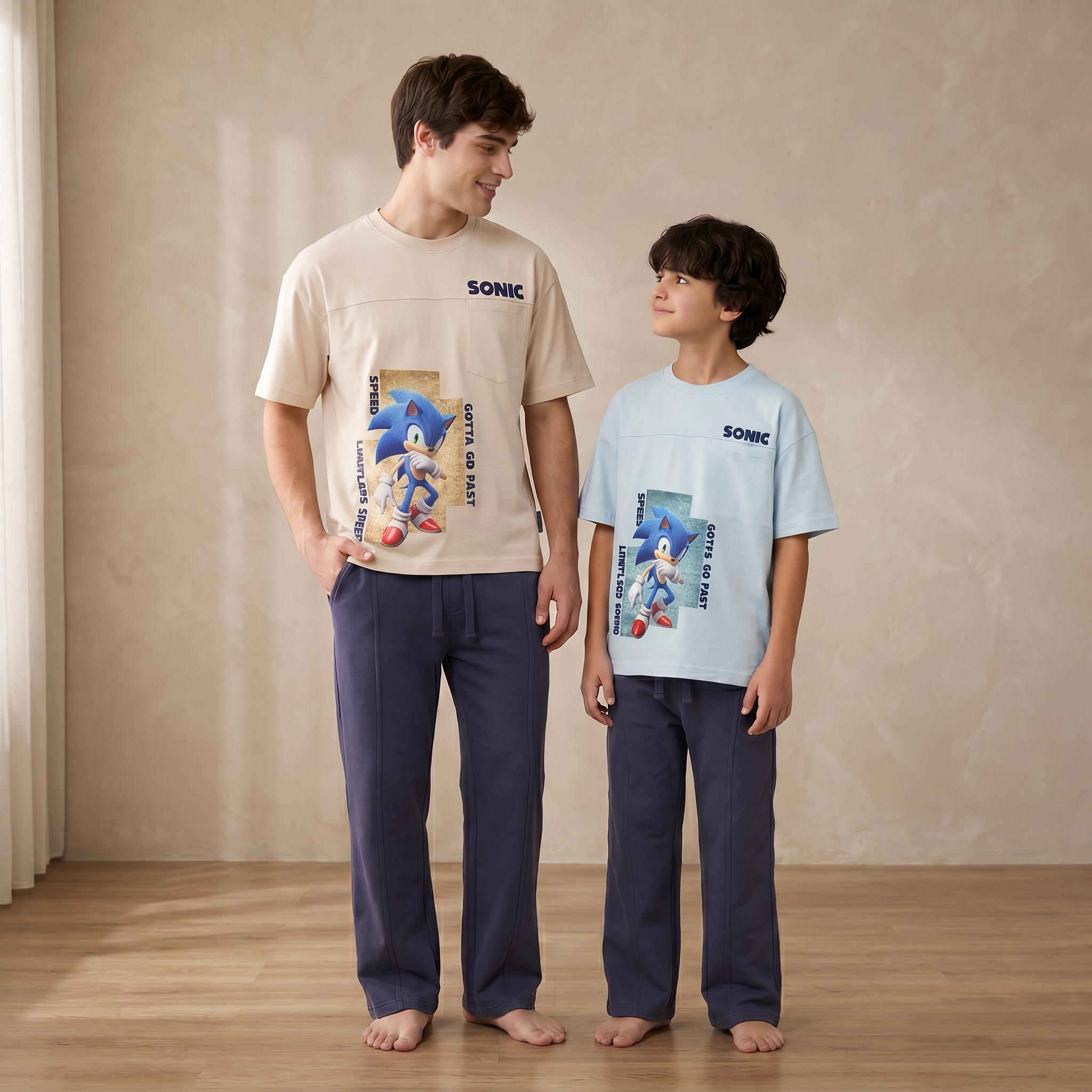 Two people wearing Sonic-themed pajamas standing in a room with a neutral background.